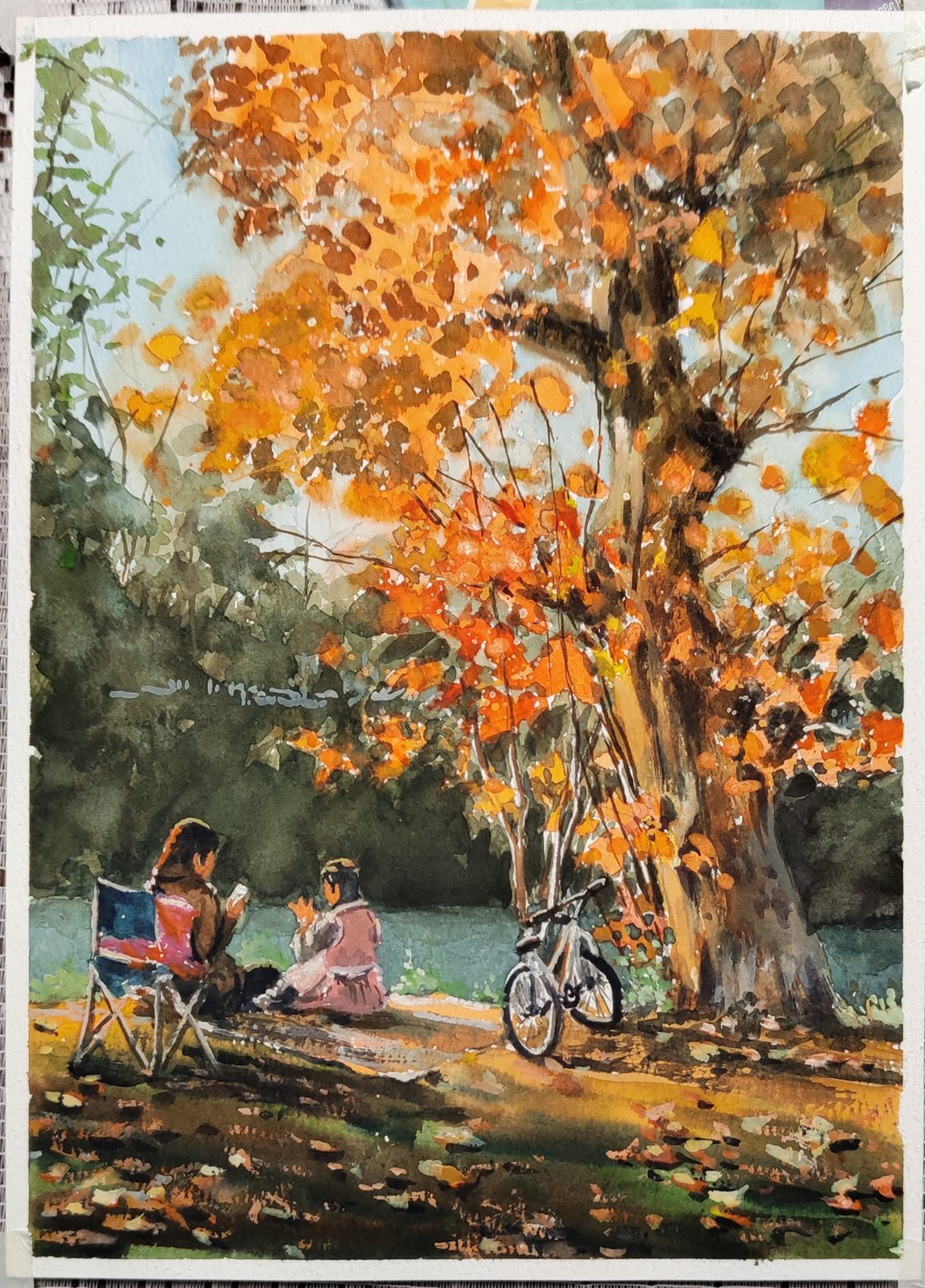 Watercolor of two people picnicking under a blazing orange maple with a bicycle