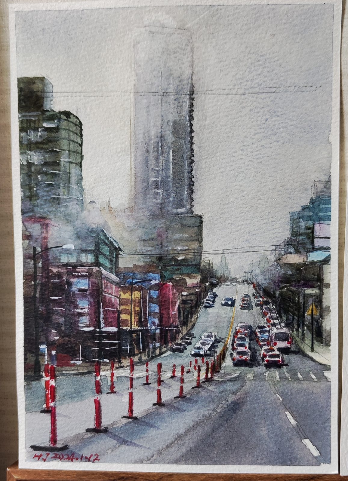 Watercolor of a foggy downtown street with a tall tower and a row of red traffic cones